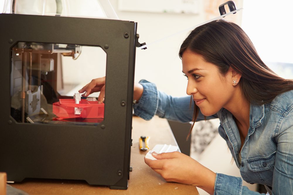 A woman working at a 3D printer.