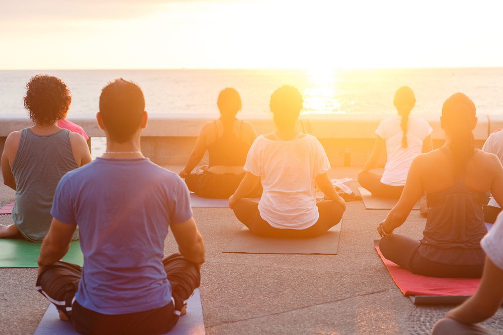 A group does yoga at sunset