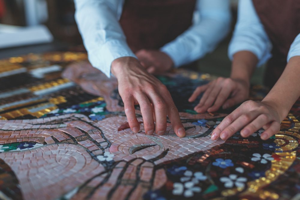 Hands making a mosaic