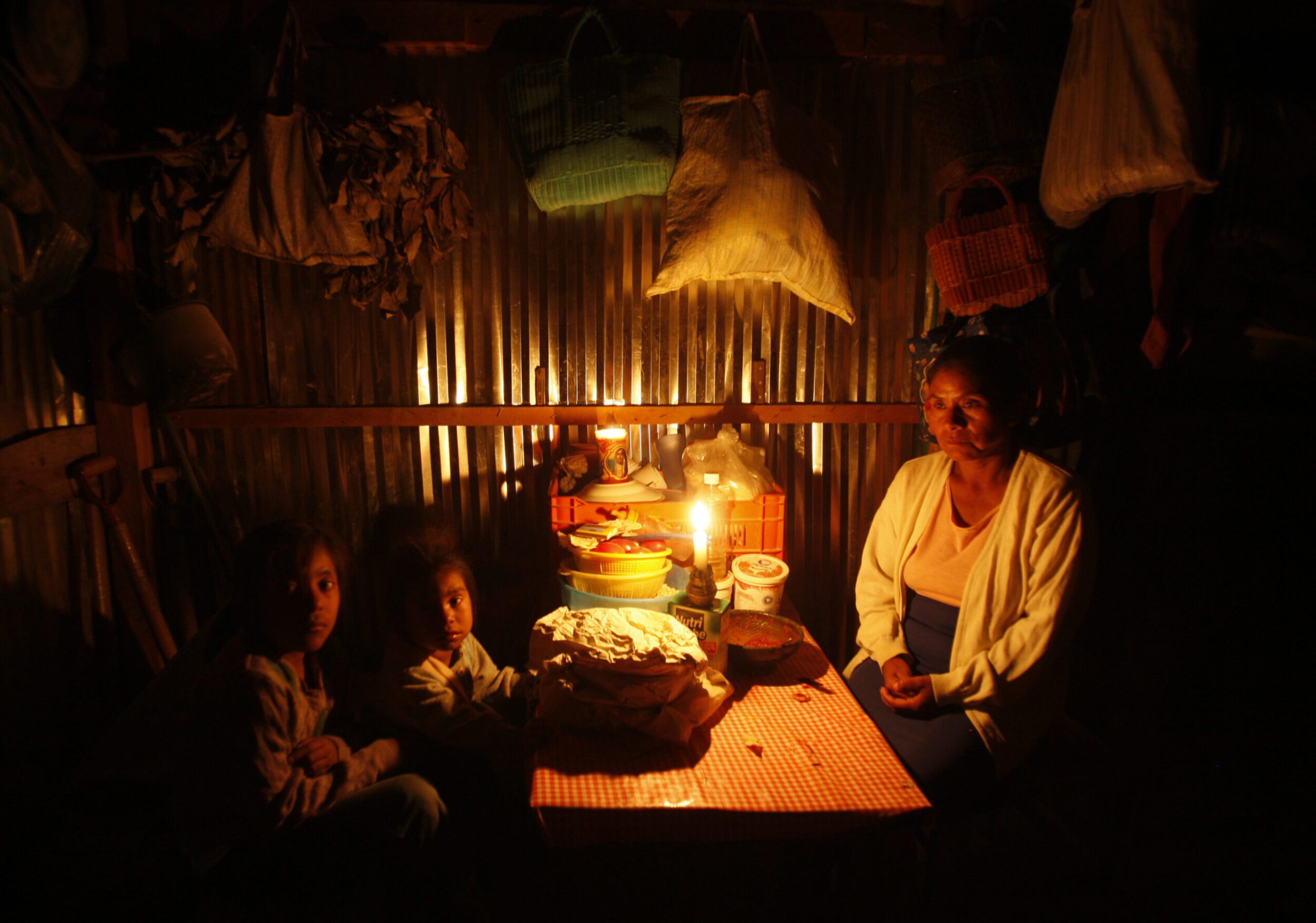 family with energy poverty sitting with candles