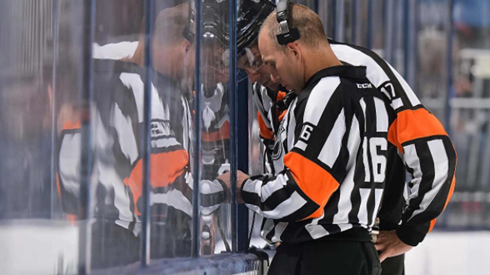 NHL refs reviewing video; Photo Credit: NHLI
