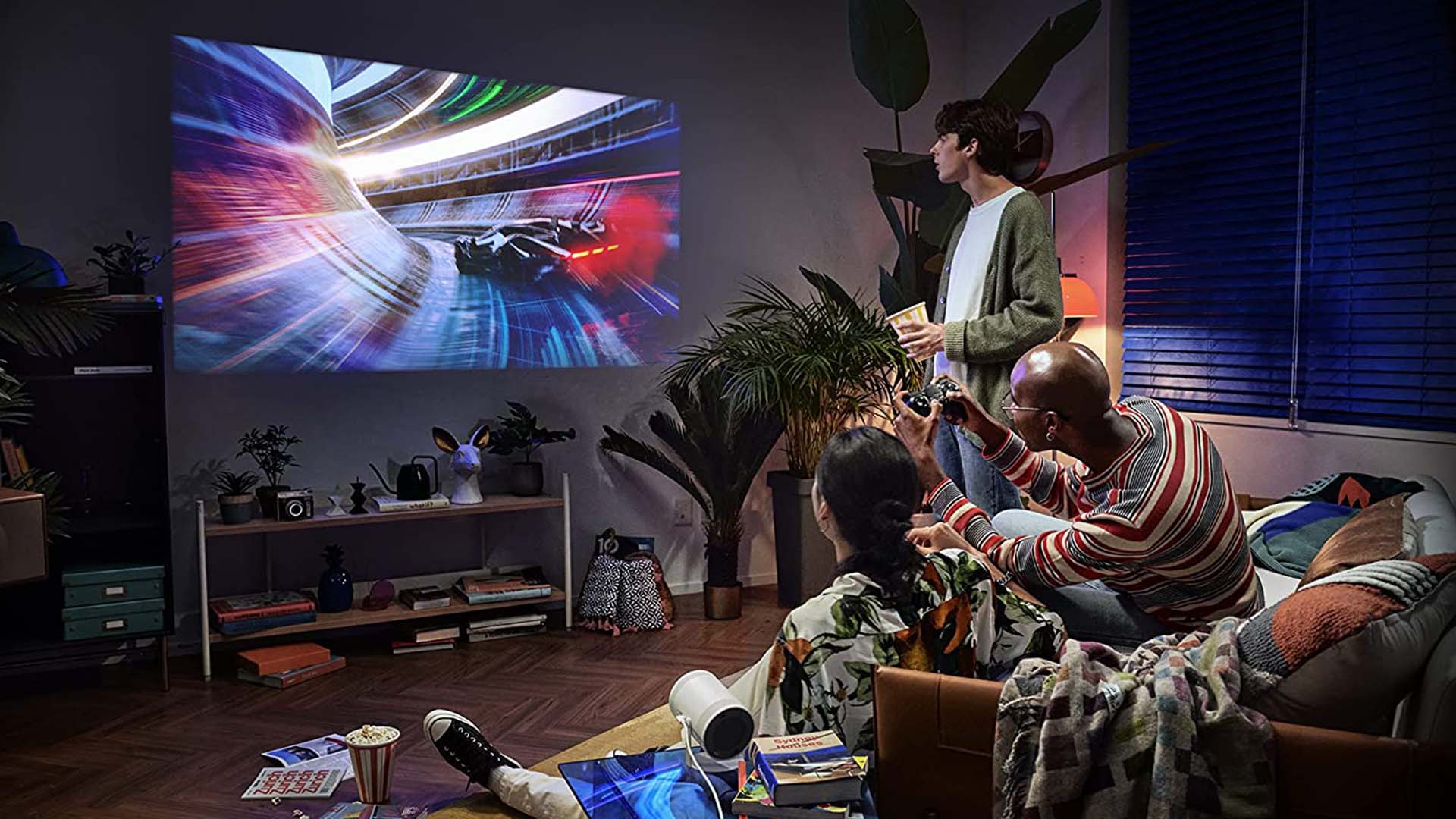A family watching TV in a living room thanks to Samsung's Freestyle Projector