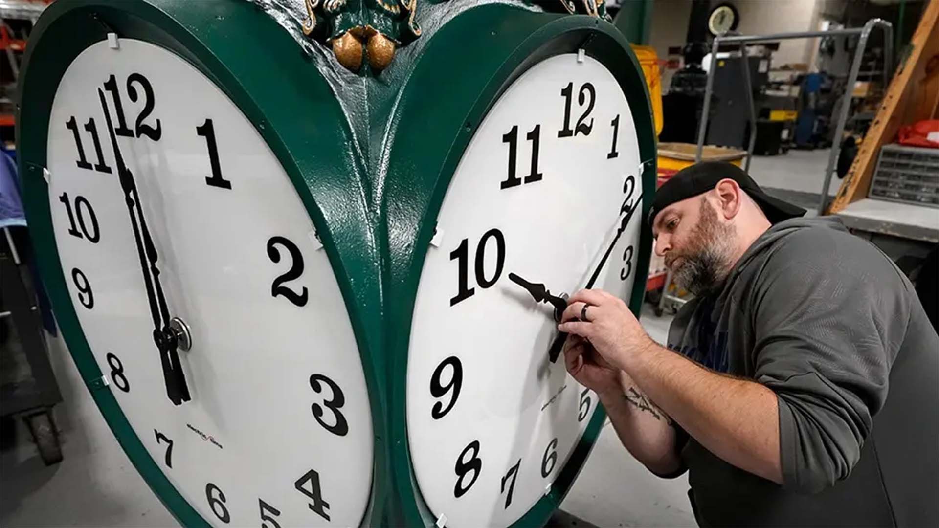 Clock technician adjusts clock for Daylight Saving Time in 2022