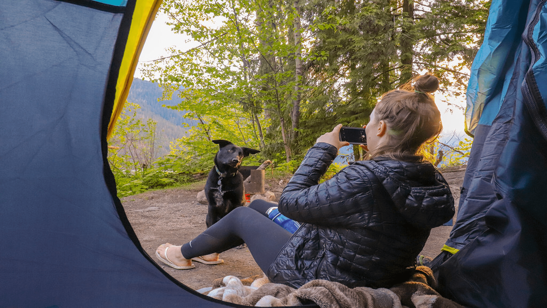 Woman taking a photo while sitting in a tent