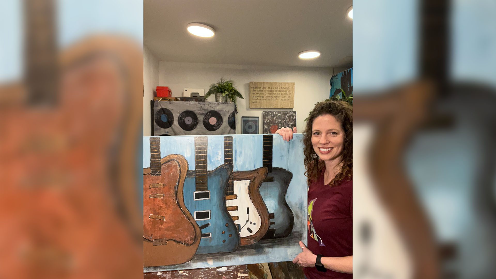 Kelly Saunders holding her art