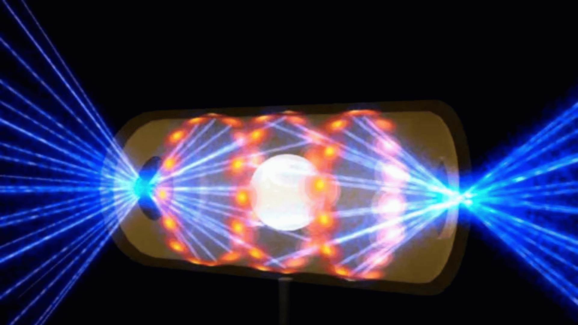Illustration depicting a target pellet inside a hohlraum capsule with laser beams entering through openings on either end. The beams compress and heat the target to the necessary conditions for nuclear fusion to occur; Photo Credit: Handout: Lawrence Livermore National Laboratory via AP Photo