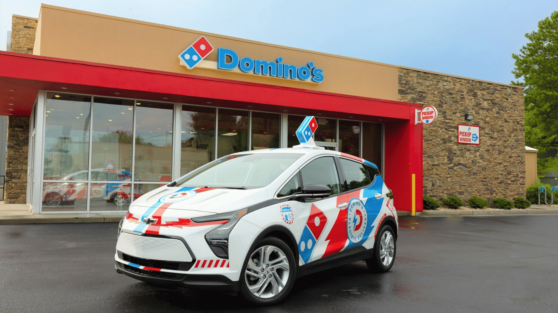 Domino's electric vehicle outside a domino's restaurant