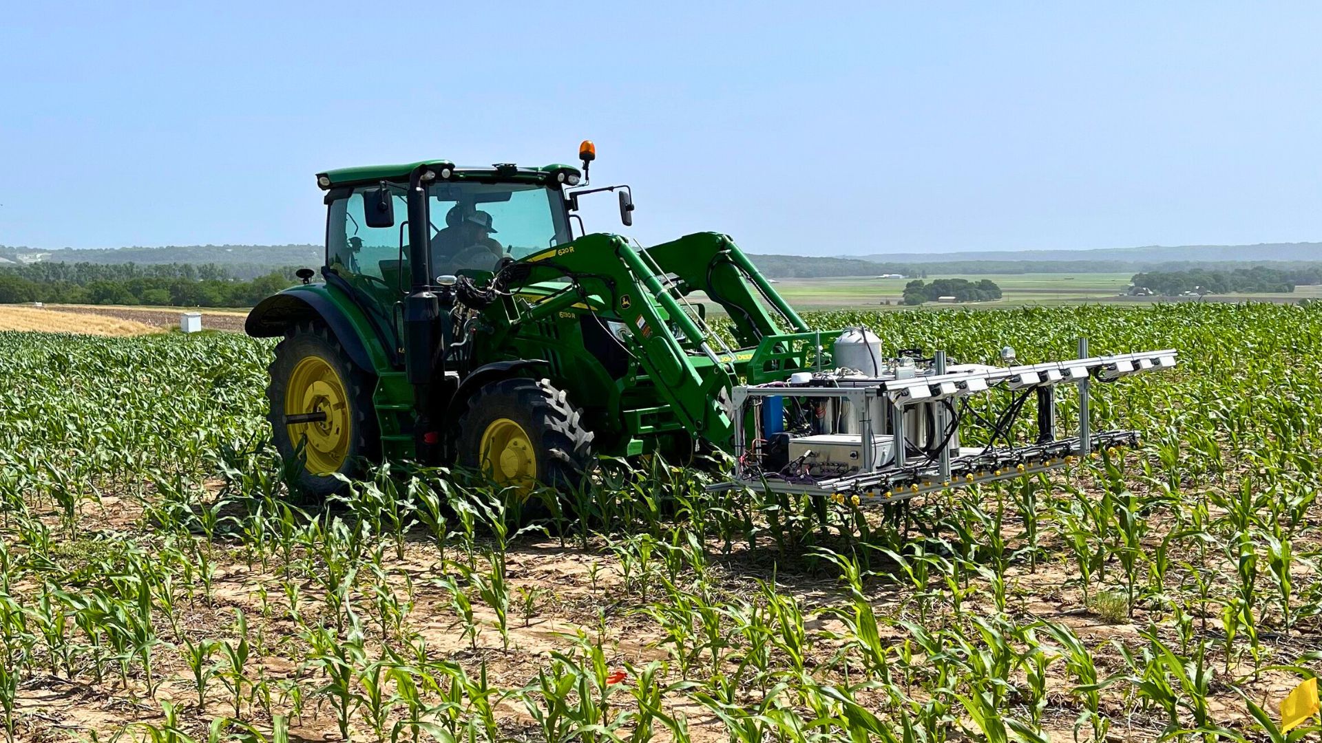 Tractor mounted AI sprayer in cornfield