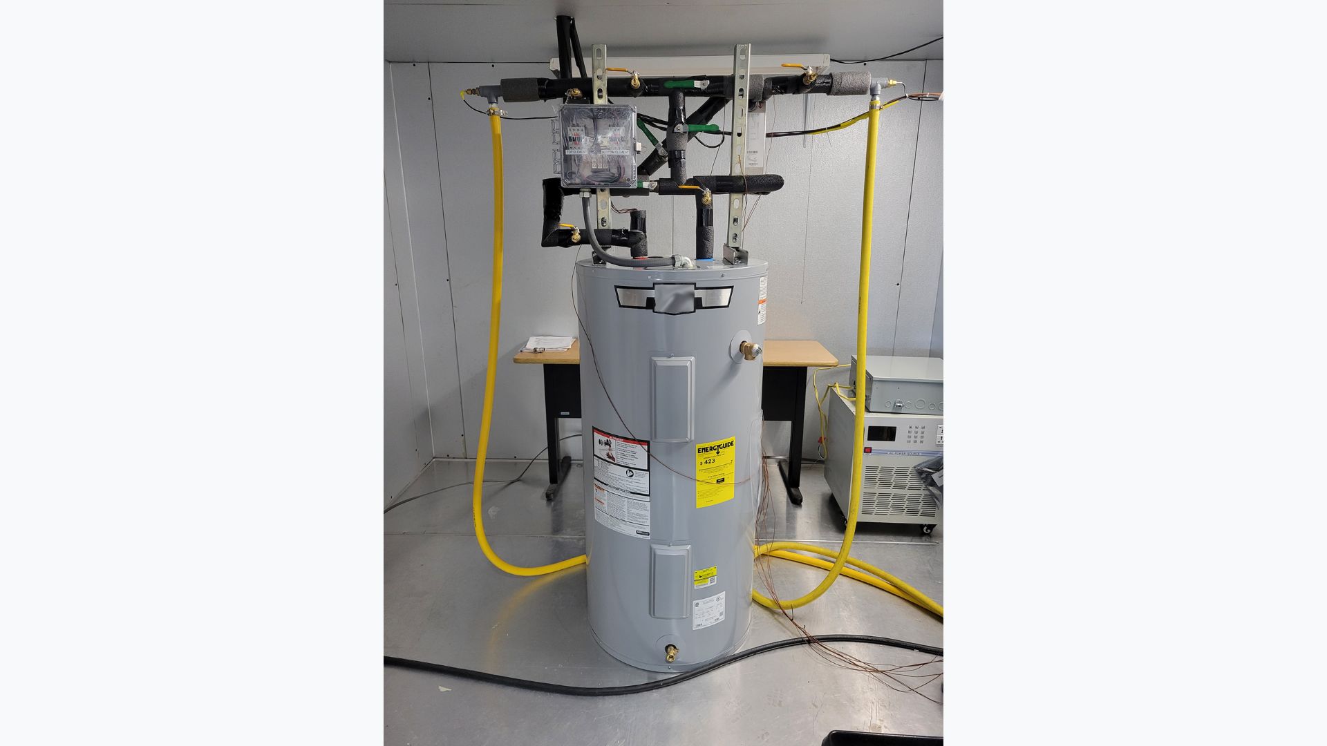 A prototype of the water heater design, with the heat exchanger visible behind the insulated pipes. Additional valves and electronics allowed researchers to control and test the system.